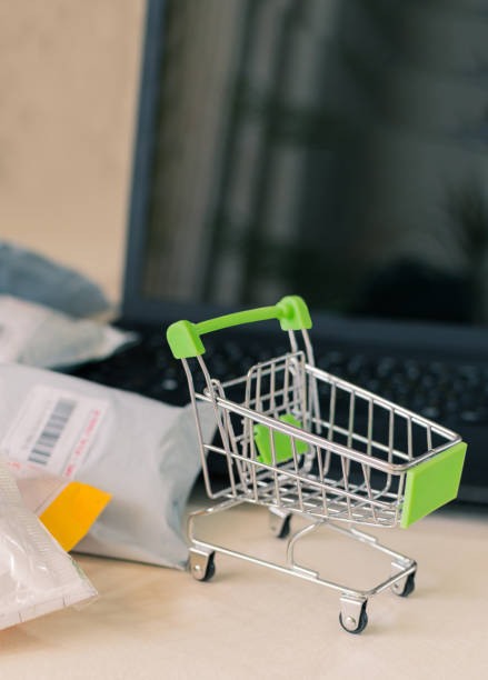 سبد خرید و بسته‌ای در کنار لپ‌تاپ برای مفهوم خرید آنلاین
