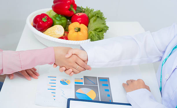 مشاوره تغذیه و سلامت متخصص تغذیه در حال مشاوره با بیمار