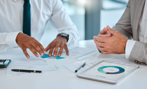 دو تاجر در حال بررسی اسناد و قرارداد در دفتر کار