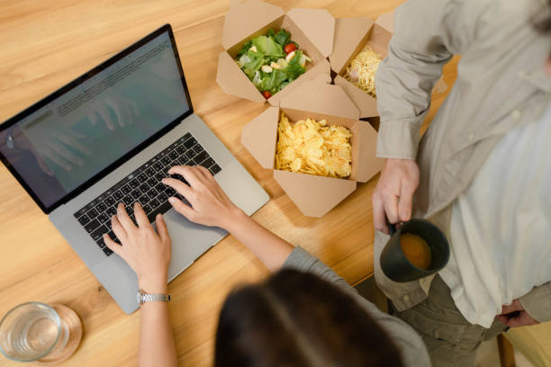 زوج جوان در حال لذت بردن از غذا و استفاده از تکنولوژیهای سفارش آنلاین دیجیتال مارکتینگ برای رستوران و جذب مشتریان مدرن