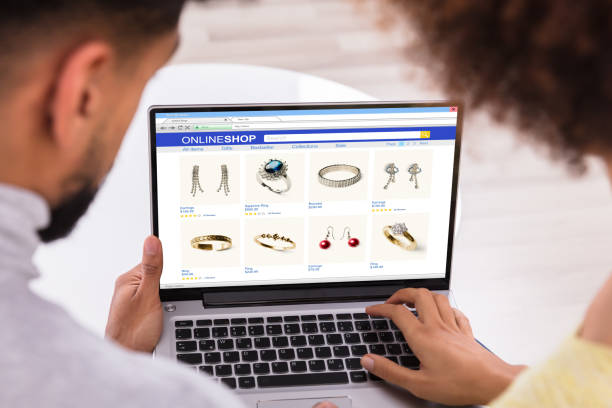 تجربه خرید آنلاین زیورآلات دستساز زوج جوان در حال خرید آنلاین زیورآلات از طریق لپتاپ