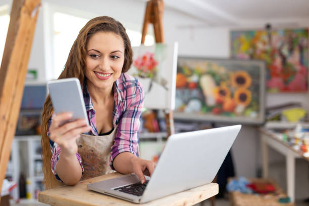 هنرمند در حال مدیریت کسب و کار آنلاین گالری هنری خود با وردپرس در استودیو