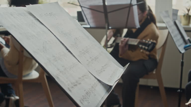 دست یک کودک در حال ورق زدن نت موسیقی برای افزایش ثبت نام آموزشگاه