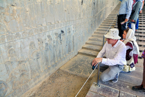 راهنمای تور تخت جمشید در حال توضیح برای گردشگران خارجی - سئو تاریخی