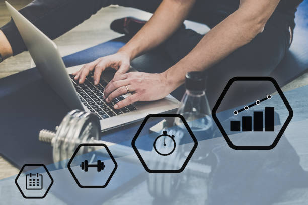 مرد ورزشکار در حال برنامه ریزی تمرین با لپ تاپ - کسب و کار آنلاین ورزشی و مدیریت باشگاه