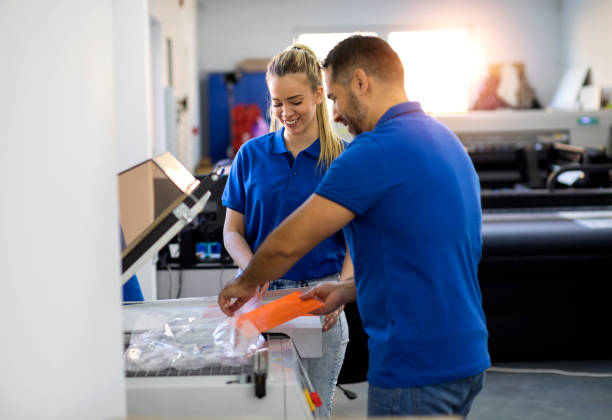 گروهی از متخصصان در یک کارخانه چاپ و بسته بندی در حال بررسی کیفیت کار