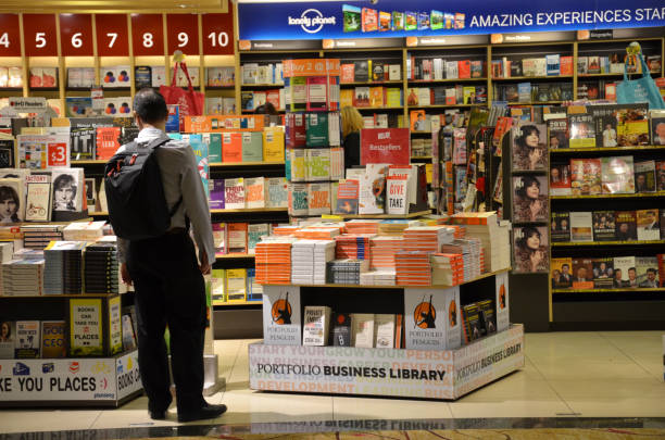 مشتریان در حال انتخاب و خرید کتاب از یک کتابفروشی مدرن، نمادی از تجربه موفق بازاریابی کتابفروشی