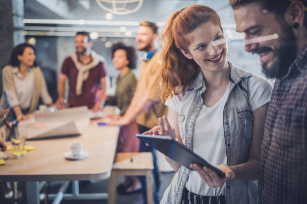 فریلنسر خوشحال در حال استفاده از تبلت دیجیتال در دفتر کار - بهبود تجربه کاربری کوورکینگ