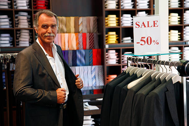 مردی در حال پرو کت و شلوار در یک بوتیک حرفه‌ای