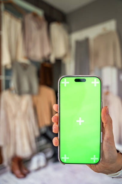 دستی در حال نگه داشتن یک گوشی هوشمند با صفحه سبز برای ماکاپ، نمادی از طراحی سایت مبلمان با پیشنمایش AR و UX در اصفهان