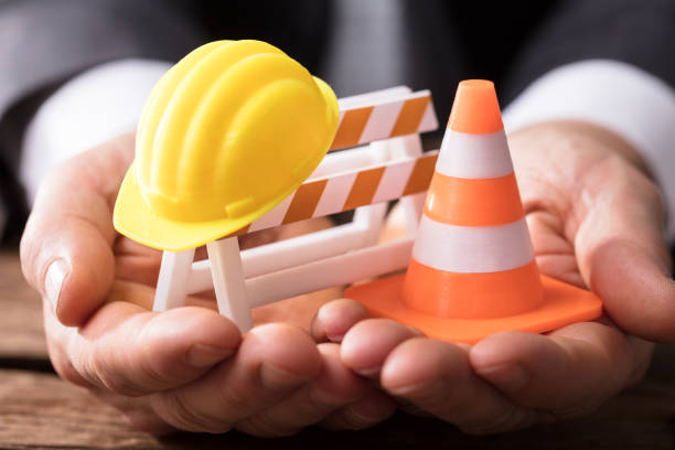 تضمین اعتبار پروژههای بزرگ در اهواز: اهمیت پشتیبانی و امنیت سایت برای شرکتهای ساختمانی - کلاه ایمنی و موانع ترافیکی نمادی از امنیت در پروژههای عمرانی