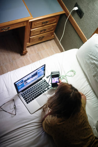 زن جوانی در حال کار با لپتاپ و موبایل در اقامتگاه بومگردی – استقلال دیجیتال اقامتگاهها