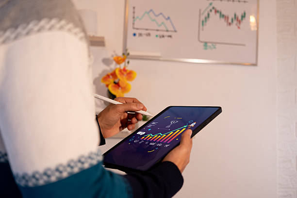 معماری اعتماد در بازار سرمایه تهران - مردی در حال مدیریت دادههای کسبوکار با تبلت
