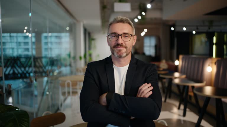 پرتره یک تاجر با بازوهای ضربدری در یک رستوران، نمادی از رهبری و استراتژیهای موفق در بازاریابی دیجیتال و جذب مشتری رستوران