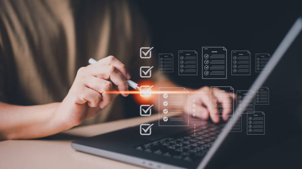 تاجر با لپتاپ در حال استفاده از فرمهای دیجیتال برای مدیریت موجودی و بهینه سازی در تولیدی پوشاک