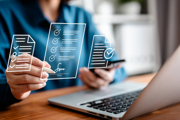 زنان بازرگان در حال امضای اسناد دیجیتال با قلم نوری بر روی صفحه نمایش مجازی لپ تاپ، نمادی از هوشمندسازی فرآیندهای مالی و بازاریابی محتوایی