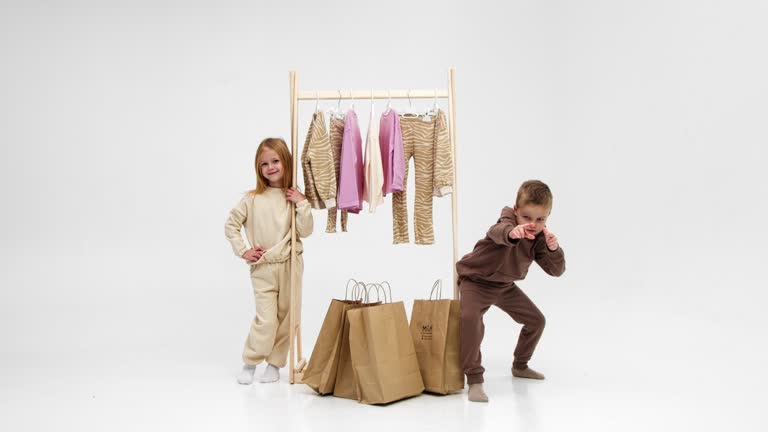 تصویر کودکان شاد با کیسههای خرید لباس، نمادی از رضایت خانوادهها پس از خرید از یک برند پوشاک بچهگانه موفق. این تصویر با عنوان 'از کارگاه اصفهان تا کمد کودکان ایران: نقش ساخت CRM و طراحی سایت D2C در وفادارسازی والدین برای برندهای پوشاک بچهگانه' و کلمات کلیدی 'ساخت CRM برند لباس بچهگانه' و 'بازاریابی دیجیتال لباس بچهگانه' مرتبط است.