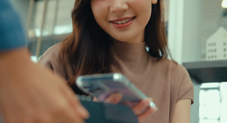 مشتری در حال انجام پرداخت آنلاین با گوشی هوشمند در کافه، نشاندهنده سهولت پرداخت در سایت D2C برای فروش مستقیم محصولات