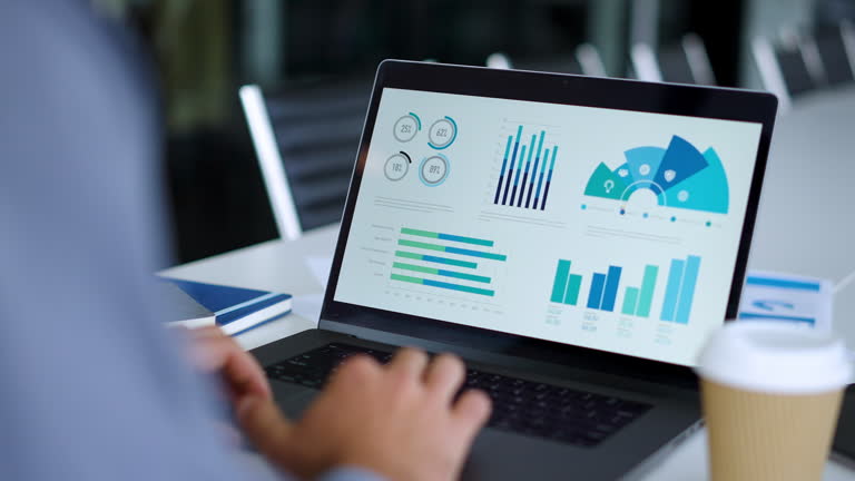 نمای نزدیک از یک تاجر که از لپتاپ خود با نمودارها و چارتها استفاده میکند، نشاندهنده تحلیل دادهها در سئو B2B و بازاریابی دیجیتال سلامت