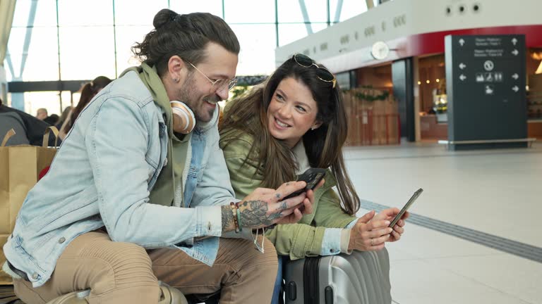 زوجی در حال استفاده از موبایل در ایستگاه قطار و جستجو برای اقامتگاه بومگردی – جذب گردشگر دیجیتال