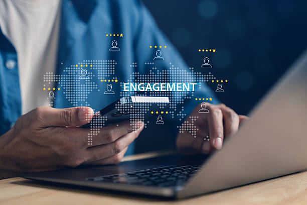 فردی در حال استفاده از گوشی هوشمند و لپتاپ برای تعامل و تحلیل دادههای دیجیتال مارکتینگ کفش برای افزایش فروش کفش در پینو سایت