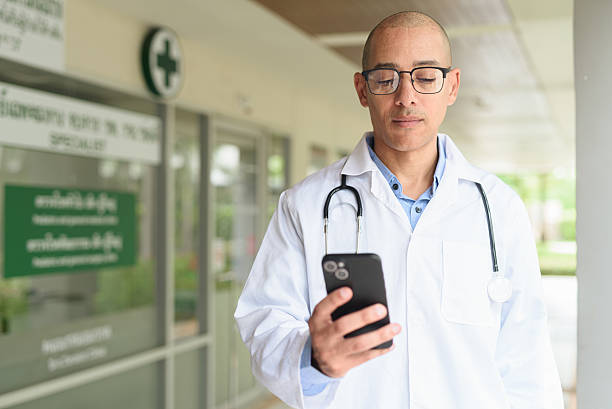 بازاریابی دیجیتال گفتاردرمانی در اصفهان - دکتر در حال استفاده از گوشی مقابل کلینیک