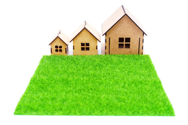 تصویر یک چمن مصنوعی در مقابل سه خانه اسباببازی. این تصویر میتواند نمادی از قابلیت واقعیت افزوده (AR) برای نمایش مجازی فرش در خانهها باشد.