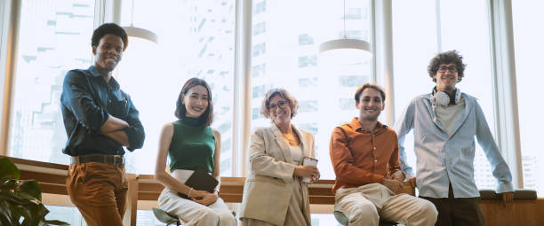 گروه چند قومیتی از مردان و زنان تجاری که لبخند میزنند و به دوربین نگاه میکنند - استراتژی جامع سئو و برندینگ دیجیتال برای جذب هنرمندان جهانی در استودیوهای ضبط