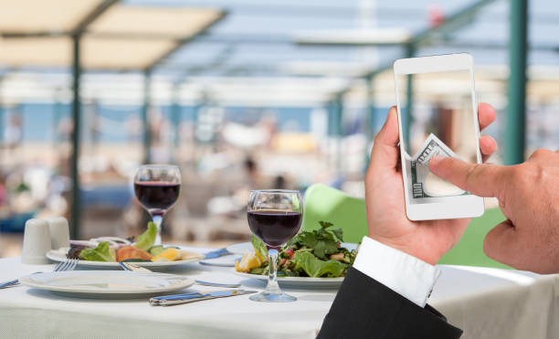 میز غذای آماده و مردی که با گوشی هوشمند پرداخت آنلاین انجام میدهد - سئو و بازاریابی دیجیتال رستوران