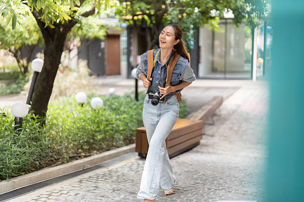 شخصی در حال کشف شهر با دوربین و کوله پشتی - طراحی وبسایت، بهینهسازی تجربه کاربری، جذب مشتری باشگاه بدنسازی