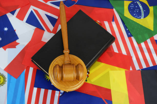 کتاب قانون و چکش عدالت بر روی پرچمهای کشورها، نمادی از سئو حقوقی بینالمللی و جذب موکلان تجاری از بازار حقوقی عراق