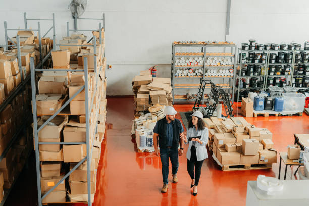 کارمند انبار با تبلت در حال بررسی شفافیت زنجیره تأمین خودرو و مدیریت هوشمند