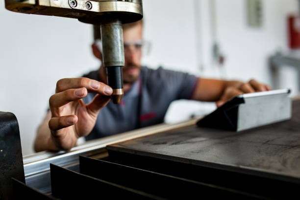 مهندس جوان در حال کار در کارگاه فلزکاری، نمادی از تخصص و دقت در کارگاه تراشکاری و اهمیت طراحی وبسایت صنعتی