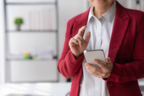 وکیل زن با لباس قرمز در حال استفاده از گوشی هوشمند، مشاوره حقوقی کسب و کار، محتوای حقوقی B2B