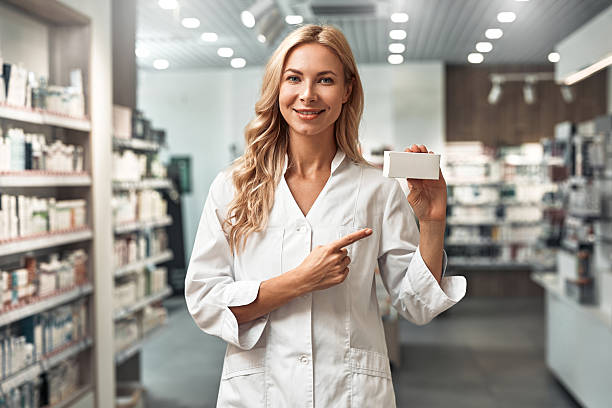 داروساز در حال ارائه جعبه دارو به مشتری در داروخانه - بازاریابی بینالمللی پزشکی، جذب توریست سلامت