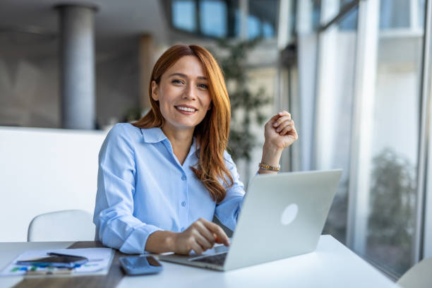 بانویی موفق در حال کار با لپتاپ برای استراتژی سئو و بهینهسازی جستجوی صوتی وکلا در ۱۴۰۵ جهت مشاوره حقوقی آنلاین و وکیل یابی اینترنتی در همدان