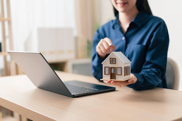 مشاور املاک در حال ارائه مدل خانه لوکس با استفاده از لپتاپ و ابزارهای دیجیتال، نمایشگر برندینگ دیجیتال