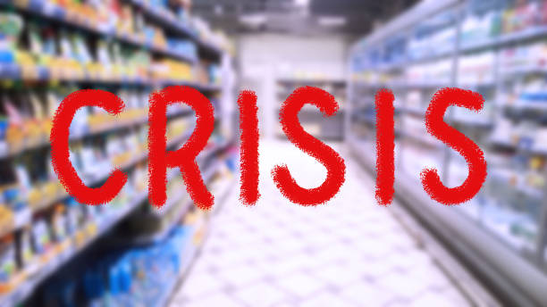 متن قرمز بحران روی تصویر تار انتزاعی از پسزمینه سوپرمارکت، همراه با نمودارهای میلهای، نشاندهنده لزوم پیشبینی بازارهای جهانی و تحول دیجیتال مارکتینگ