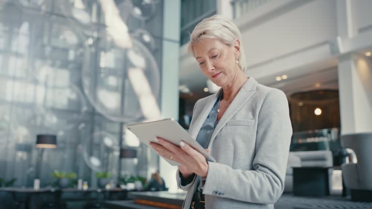 خانمی با تبلت در حال بررسی وضعیت وبسایت، نمادی از تجربه کاربری مطلوب در رزرو آنلاین هتل و اعتماد به سیستم