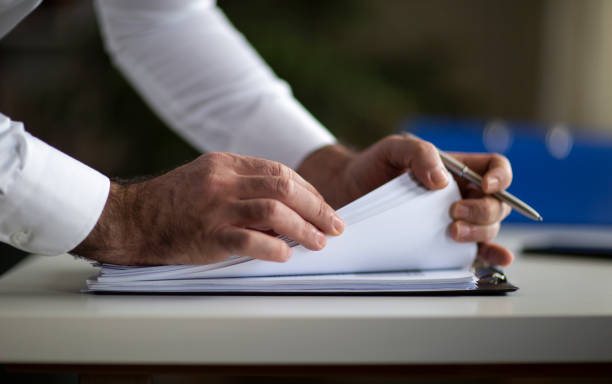 طراحی سایت املاک و جلب اعتماد خریدار: مرد کت و شلوارپوش با فرم پیشنهاد بیمه، نمادی از تخصص و شفافیت