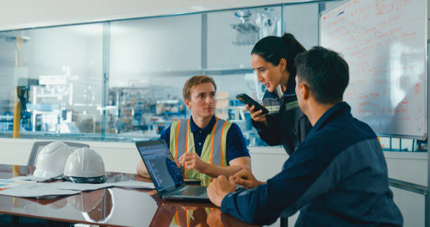 تیمی از مهندسان در یک جلسه، از لپتاپ و اپلیکیشن ترجمه استفاده میکنند، نمادی از همکاری انسان و هوش مصنوعی در پلتفرم ترجمه هیبریدی