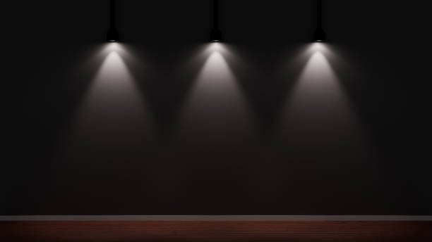 سه نورافکن دیوار سیاهی را در استودیویی تاریک با کف چوبی روشن کردهاند - نمایش هنر نصف جهان در فضای دیجیتال: استراتژی جامع بهینهسازی تجربه کاربری و طراحی سایت گالری مجازی برای گالریهای هنری اصفهان