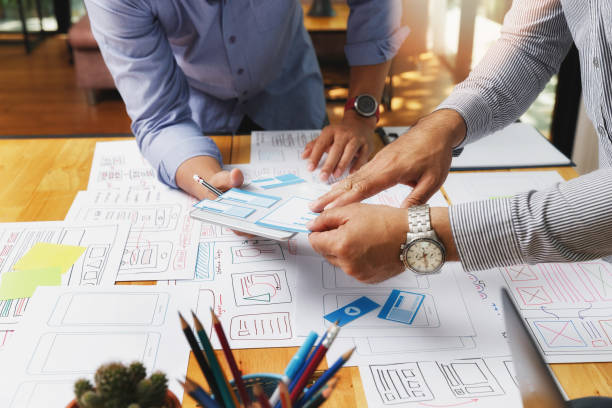 طراحان UX/UI در حال کار بر روی پروتوتایپ طرح برنامه گوشی هوشمند - طراحی تجربه کاربری، UX در معماری، تحول دفاتر معماری