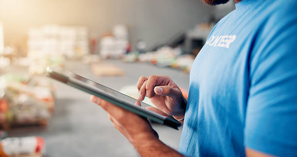 فردی در حال کار با تبلت برای مدیریت موجودی و لیست بررسی - پشتیبانی سایت و مدیریت دیجیتال