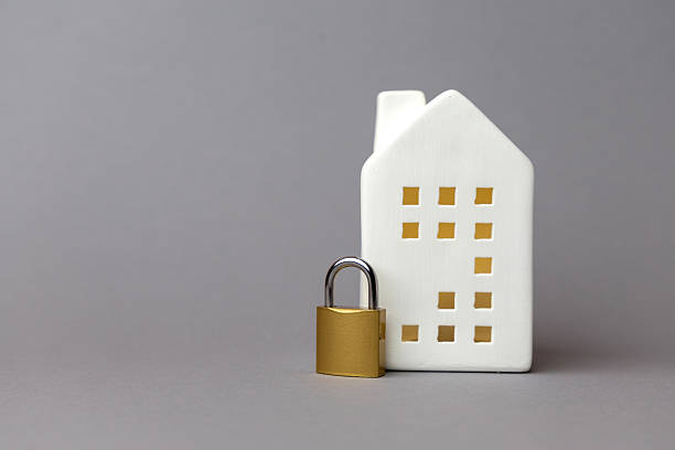 تصویری از یک خانه سفید با نماد قفل طلایی که امنیت و حفاظت مالی را در زمینه معماری اعتماد دیجیتال و پورتال مشتری امن شرکتهای حسابرسی در زنجان نشان میدهد.