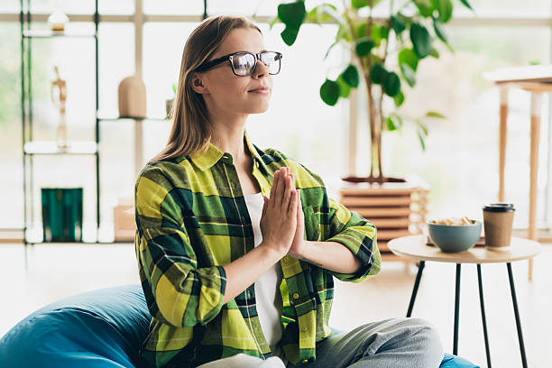 زن در حال مدیتیشن در آپارتمانی روشن، نمادی از تمرکز و آرامش که در بهینهسازی تجربه کاربری آموزشگاه و سئو آموزشگاه آرایشگری در مشهد مهم است