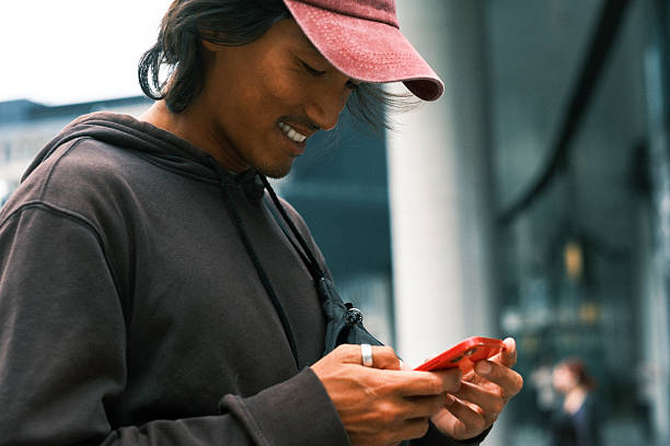 مسافر آسیایی جوان در حال رزرو پرواز و قطار با تماس تلفنی: میزبانی هوشمند در سواحل بوشهر، بهینهسازی تجربه کاربری (UX) با هوش مصنوعی برای افزایش رزرو مستقیم در سایتهای کرایه ویلا