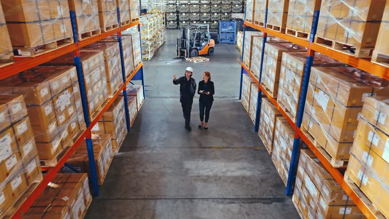 یک کارگر زن در انبار در حال مدیریت موجودی، نمادی از کارایی پورتال B2B و شفافیت زنجیره تامین در کارخانجات پلاستیک