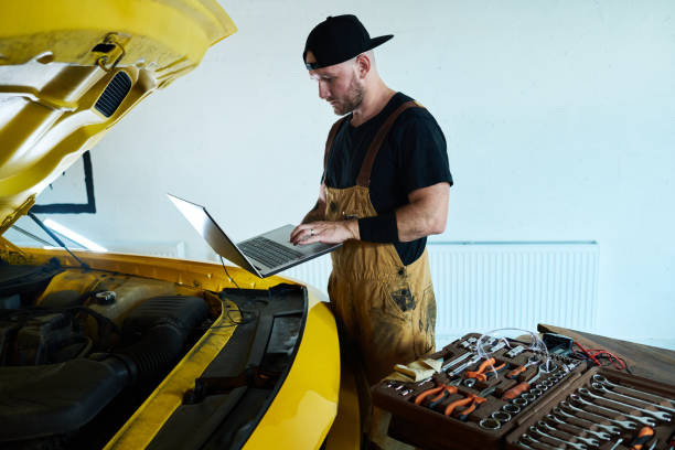 تعمیرکار جوان در حال سرویس خودرو با کاپوت باز - پشتیبانی سایت خودرویی و تعمیرات مدرن