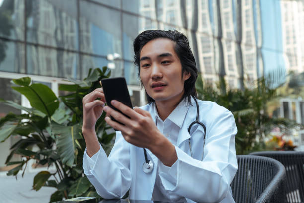 تضمین اعتماد بیماران در تبریز: پزشک در حال استفاده از موبایل برای نوبت دهی آنلاین - اعتماد بیماران آنلاین، پشتیبانی سایت کلینیک